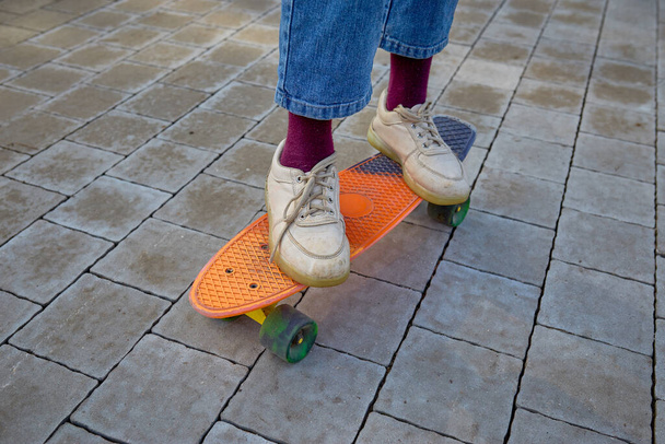 Дитячі ноги в кросівках крупним планом на скейтборді на Дереві. Фізичний розвиток дітей
. - Фото, зображення