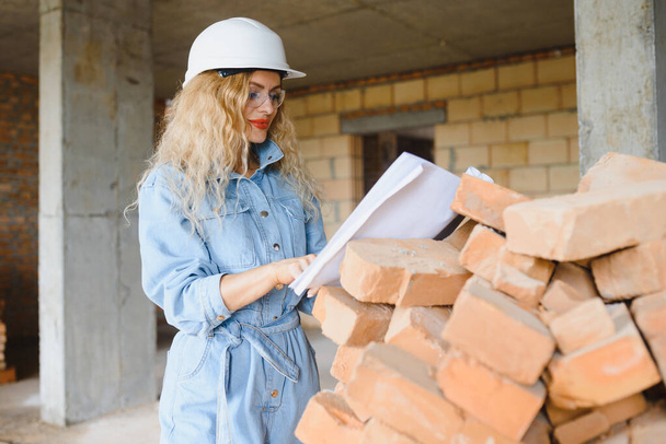 Warehouse woman worker. Woman builder in hardhat. Girl engineer or architect. Home renovation. Quality inspector. Construction job occupation. Construction worker. Lady at construction site. - Fotoğraf, Görsel