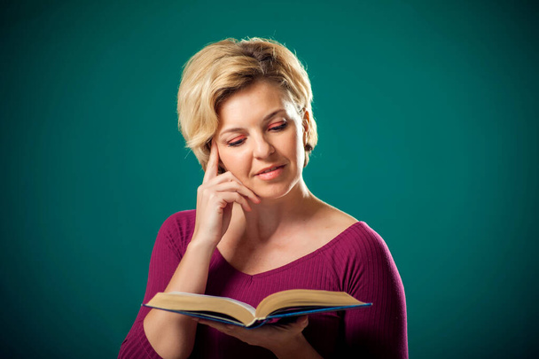 Frau mit kurzen blonden Haaren hält Buch in Händen. Menschen, Lebensstil und Bildungskonzept - Foto, Bild