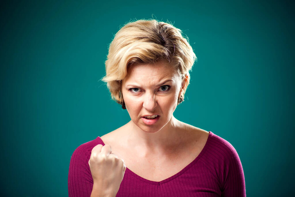 Wütende Frau mit kurzen blonden Haaren, die Fäuste in die Kamera zeigt. Menschen, Lebensstil und Emotionen - Foto, Bild