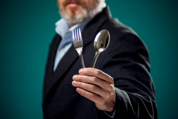 Portrét hladového vousatého muže v obleku držícího lžíci a vidličku.  - Fotografie, Obrázek