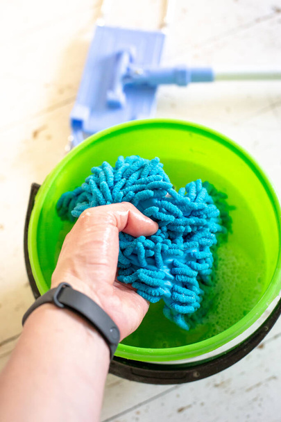 Washing a doormat in a bucket of water. Room cleaning. - Foto, immagini