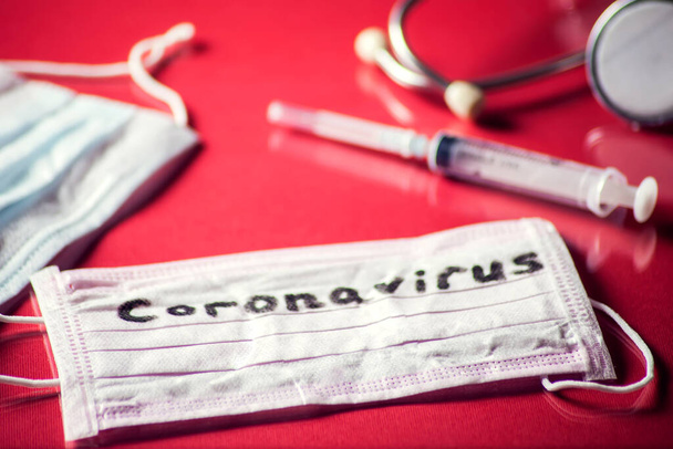 Маска со словом-коронавирус, лекарства на красном фоне. Концепция медицины и здравоохранения - Фото, изображение