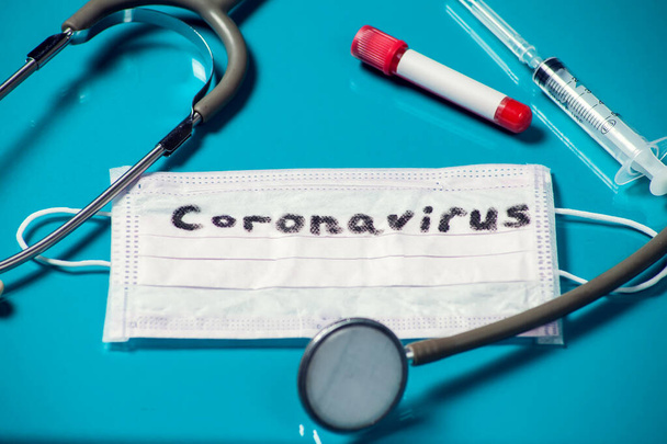 Kelime-koronavirüs maskesi, mavi arka planda ilaç malzemeleri. Medine ve sağlık hizmeti kavramı - Fotoğraf, Görsel