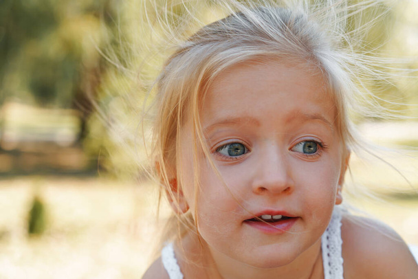 Close up portrait of a little blonde girl on a summer day - Photo, image