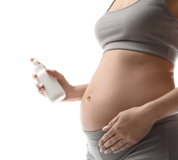 Pregnant woman with cosmetic product on white background, closeup - Fotografie, Obrázek