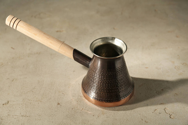 Beautiful copper turkish coffee pot on light table - Foto, Imagem