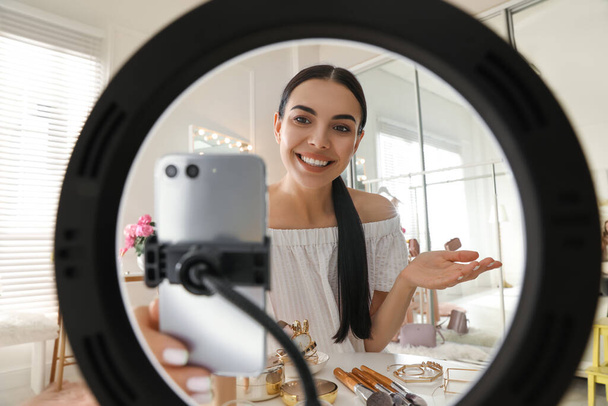 Beauty blogger recording video in dressing room at home, view through ring lamp - Zdjęcie, obraz