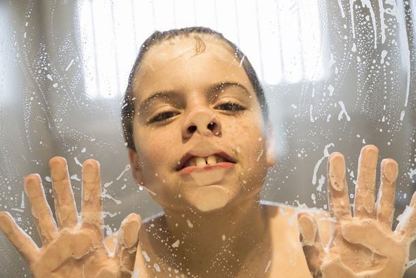 Jeune garçon jouant sous la douche
 - Photo, image