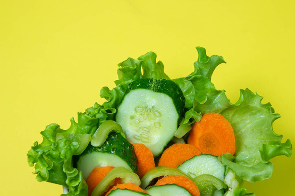 Πεντανόστιμη σαλάτα λαχανικών σε κίτρινο φόντο. Υγιεινή διατροφή φτιαγμένη από φρέσκα λαχανικά. Χορτοφαγικά τρόφιμα - Φωτογραφία, εικόνα