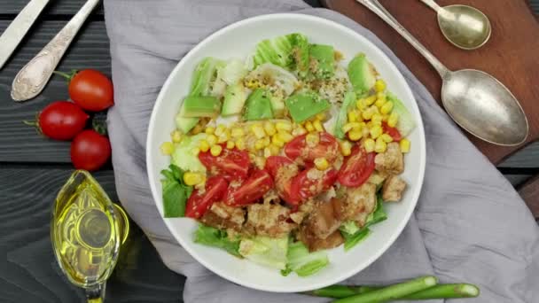 Veganistische gezonde regenboogsalade met quinoa, tofu, avocado en boerenkool, witte achtergrond. Gezond schoon eetconcept. Zwarte houten ondergrond - Video