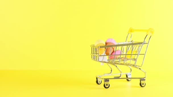 Warenkorb mit Eis drinnen auf gelbem Hintergrund, Nahaufnahme. Black Friday Shopping und Discount-Konzept. - Filmmaterial, Video
