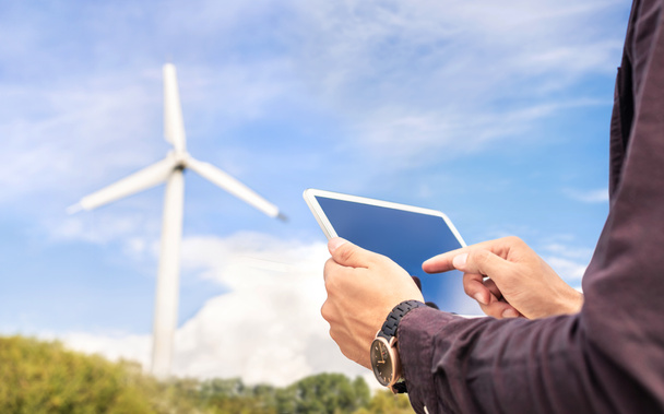 Wind power and sustainable energy field worker with tablet. Engineer or technician in green renewable electricity generation industry. People in windmill turbine inspection, maintenance or engineering - Photo, Image