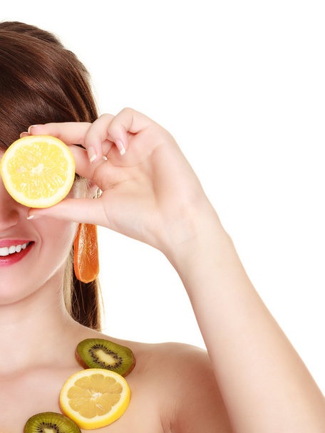 Girl in fruit necklace covering eyes with lemon - Zdjęcie, obraz