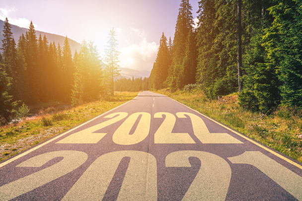 Tyhjä asfalttitie ja uudenvuoden 2022 konsepti. Ajamme tyhjää tietä vuorilla tulevaan vuoteen 2022 ja jätämme taaksemme vanhan vuoden 2021. Menestyksen ja ajan kulumisen käsite. - Valokuva, kuva
