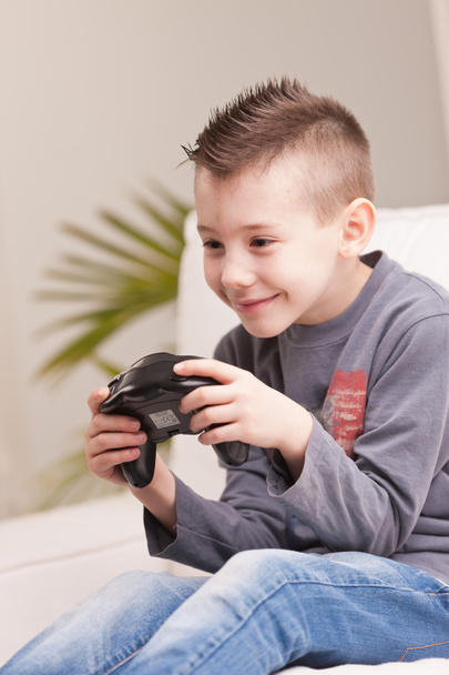 小さな男の子がビデオゲームをしていて - 写真・画像