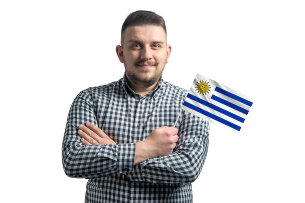 Fehér fickó kezében egy zászló Uruguay mosolygós magabiztos keresztbe karok elszigetelt fehér háttér. - Fotó, kép
