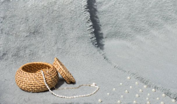 Una caja de cañas con perlas sobre un fondo gris. Concepto minimalista - Foto, imagen