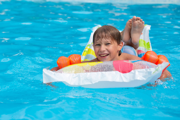 Szczęśliwe dziecko bezpiecznie pływa w basenie na materacu i w opaskach - Zdjęcie, obraz