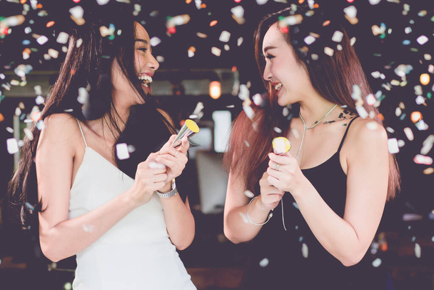 celebration party group of Two asian young  women people holding confetti happy and funny concept. In 2018 New year holiday. - Photo, Image