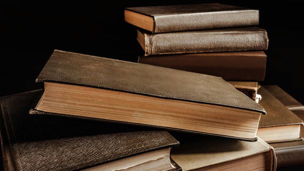 Photo of old fashioned stack of books on dark background. - Photo, Image