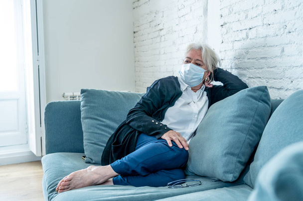 Lonely and sad senior woman in face mask feeling scared, hopeless and depressed, worried about husband tested positive for coronavirus. Elderly grieving the lost of the loved one due to COVID-19. - Foto, Imagem