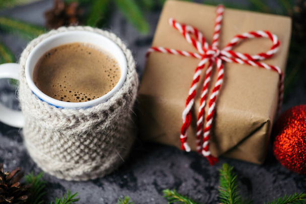 Hot morning coffee and Christmas gift on the table with tree branches - Photo, Image