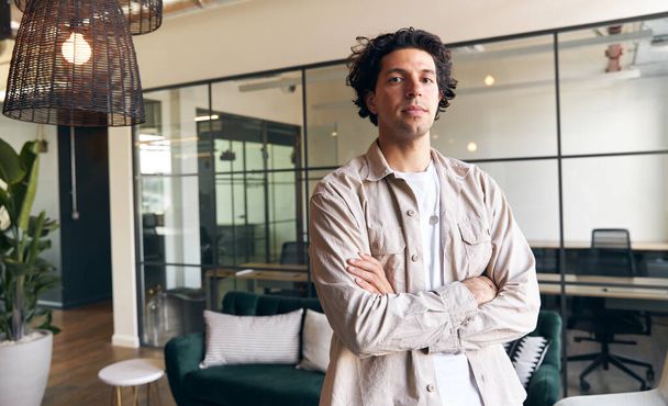 Portrét ležérně oblečeného mladého muže stojícího v moderní otevřené kanceláři svého nového podniku - Fotografie, Obrázek