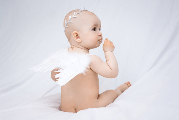 małe dziecko, niemowlę z anielskimi skrzydłami na białym tle. - Zdjęcie, obraz