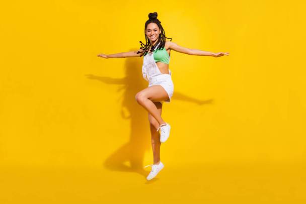 Full body photo of afro american young funky happy woman jump up hands wings isolated on yellow color background - Foto, Imagem
