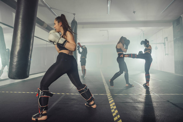 ボクサー女性。ボクシングフィットネスの女性は幸せな黒のボクシングの手袋を身に着けて笑顔。スポーティなフィット感の肖像｜ボクシングジムのアジアモデル - 写真・画像