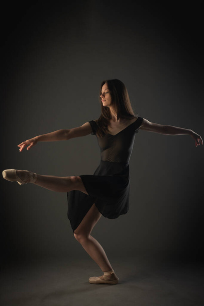 Elegante bailarina en zapatos puntiagudos mantiene una postura perfecta mientras se equilibra en una pierna - Foto, Imagen