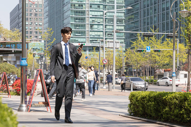 Asian man employee on smartphone in company, business communication concept - Fotó, kép