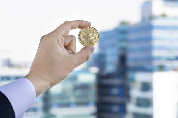 bitcoin in businessman, city buildings background - Photo, Image