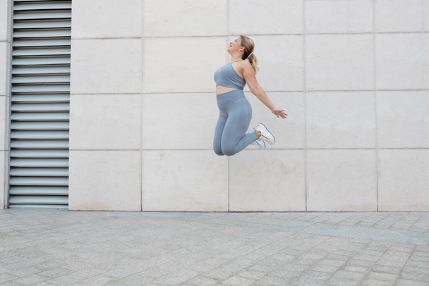 Feliz animado além de tamanho jovem mulher pulando alto no ar - Foto, Imagem