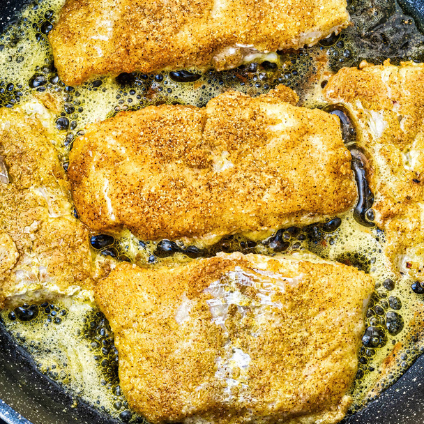 Breaded white fish steaks, fried in a pan with vegetable oil. - Photo, Image