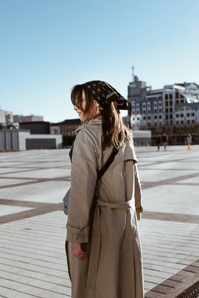 Beautiful young caucasian woman wearing trench coat walking in the city - Foto, Imagem