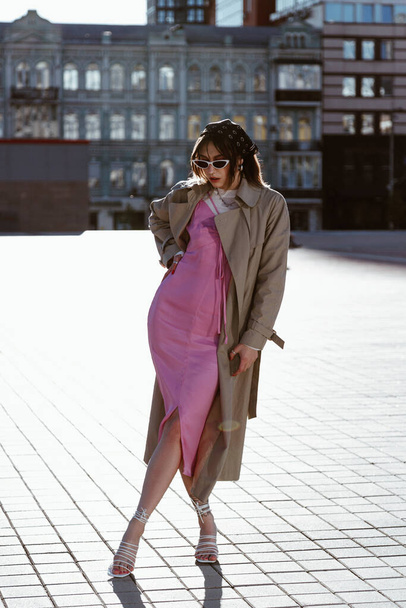 Beautiful young caucasian woman wearing trench coat in the city - Photo, Image