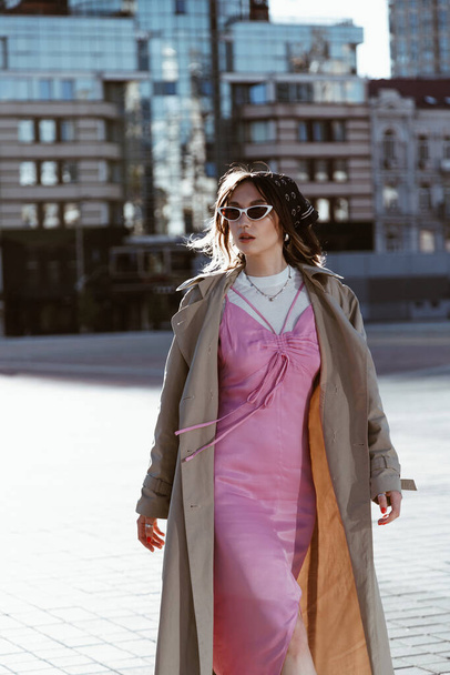 Beautiful young caucasian woman wearing trench coat walking in the city - Valokuva, kuva