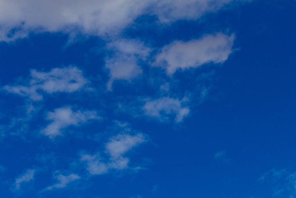 Blue summer sky with white clouds making whimsical shapes just like nature is - 写真・画像
