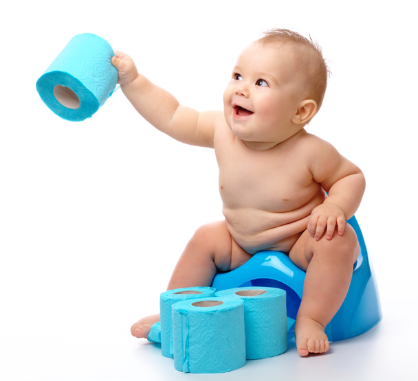 Child on potty play with toilet paper, isolated over white - Zdjęcie, obraz