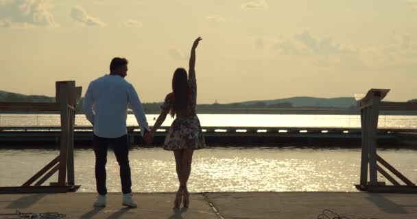 Romanttinen pari ottaa päivämäärä pengerrys auringonlaskun aikaan - Materiaali, video