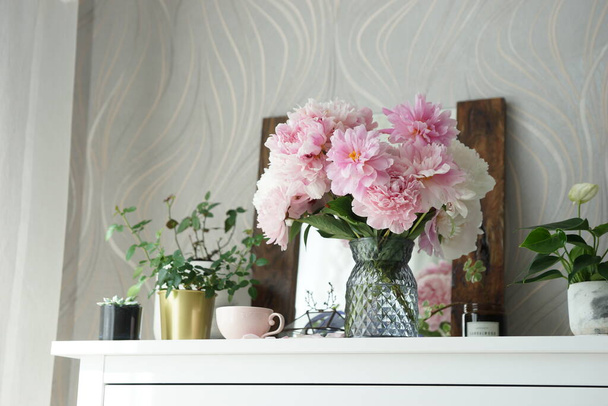Bouquet of pink peonies on the dresser in the bedroom - Foto, imagen