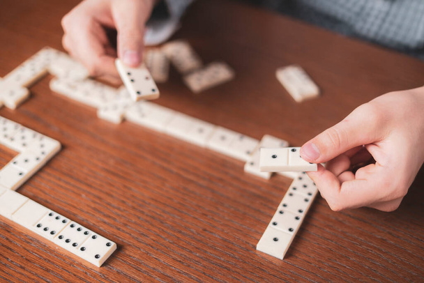 zblízka ruční držení domino kus na dřevěném stole f - Fotografie, Obrázek