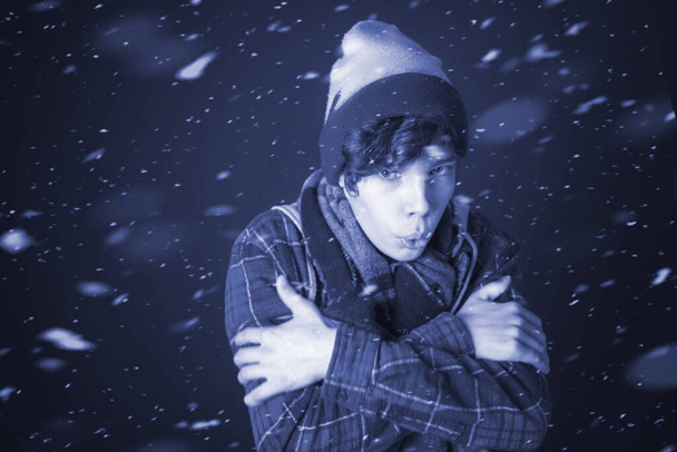 young male get frozen and wear warm clothes in chilly snowy day b - Фото, зображення
