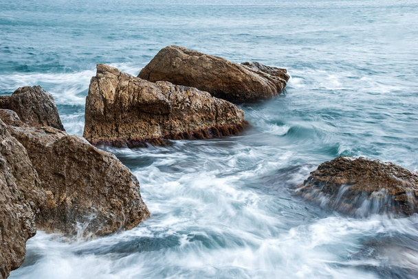 Seascape of the Crimean coast. Waves break into beautiful splashes against rocks. - Zdjęcie, obraz
