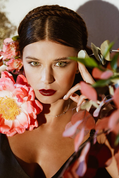 Portrait de belle jeune femme avec des fleurs de pivoine - Photo, image