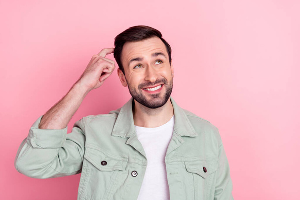 Photo of nice optimistic brunet man look empty space wear grey shirt isolated on pastel pink color background - Zdjęcie, obraz