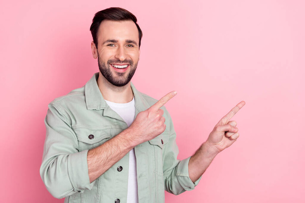 Photo of nice optimistic brunet man point empty space wear grey shirt isolated on pastel pink color background - Φωτογραφία, εικόνα