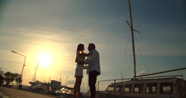 Ρομαντικό ζευγάρι που έχουν ημερομηνία στο ανάχωμα κατά το ηλιοβασίλεμα - Πλάνα, βίντεο